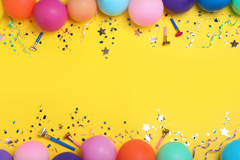 Flat lay composition with birthday decor on yellow background,